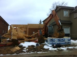 Building frame snow covered ground with heavy equipment